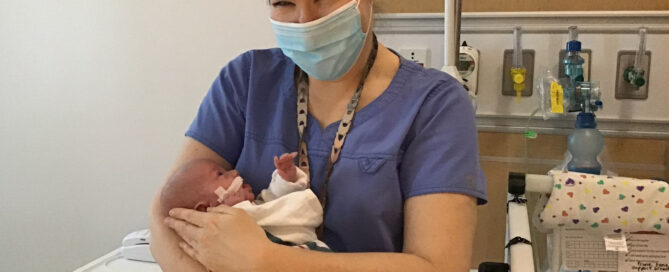 Dr. Maitre holds a NICU baby