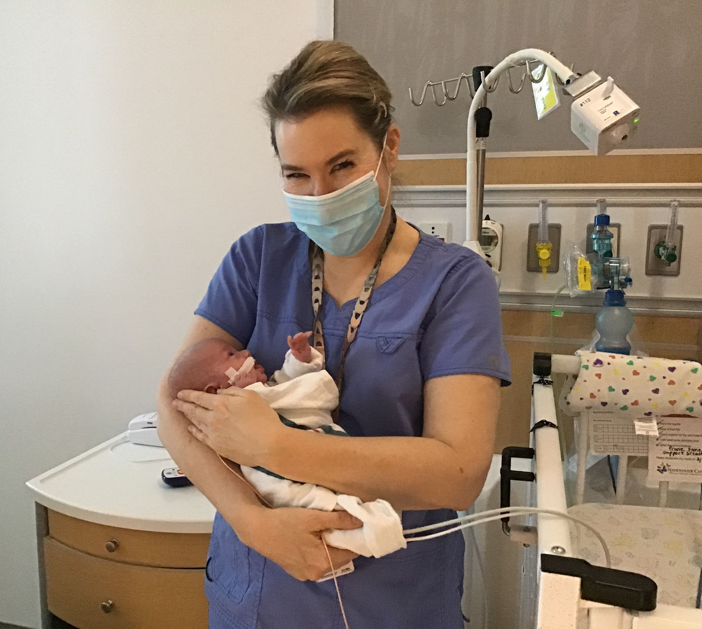 Dr. Maitre holds a NICU baby